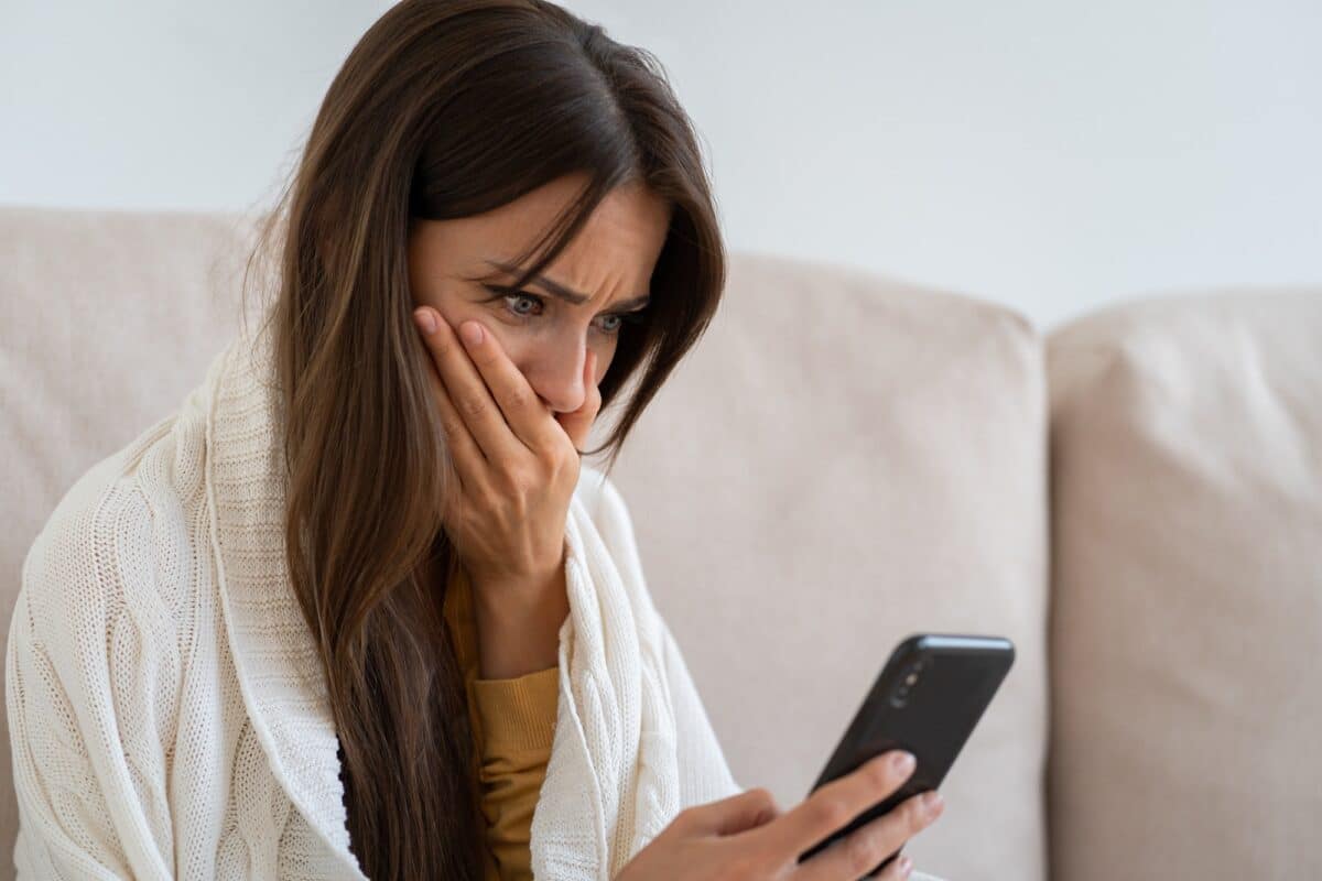 Life troubles, break up with boyfriend, heartbreak. Worried woman holds mobile phone read message