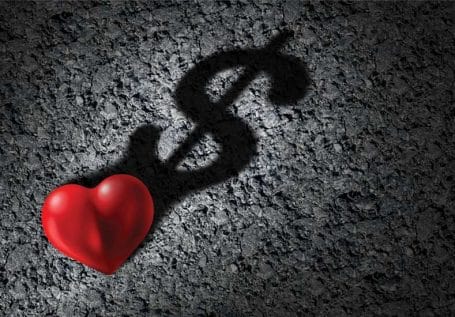 Μια κόκκινη καρδιά που η σκιά της είναι στο σχήμα του δολαρίου.