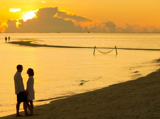 Ζευγάρι (άνδρας και γυναίκα) στην παραλία με φόντο το ηλιοβασίλεμα