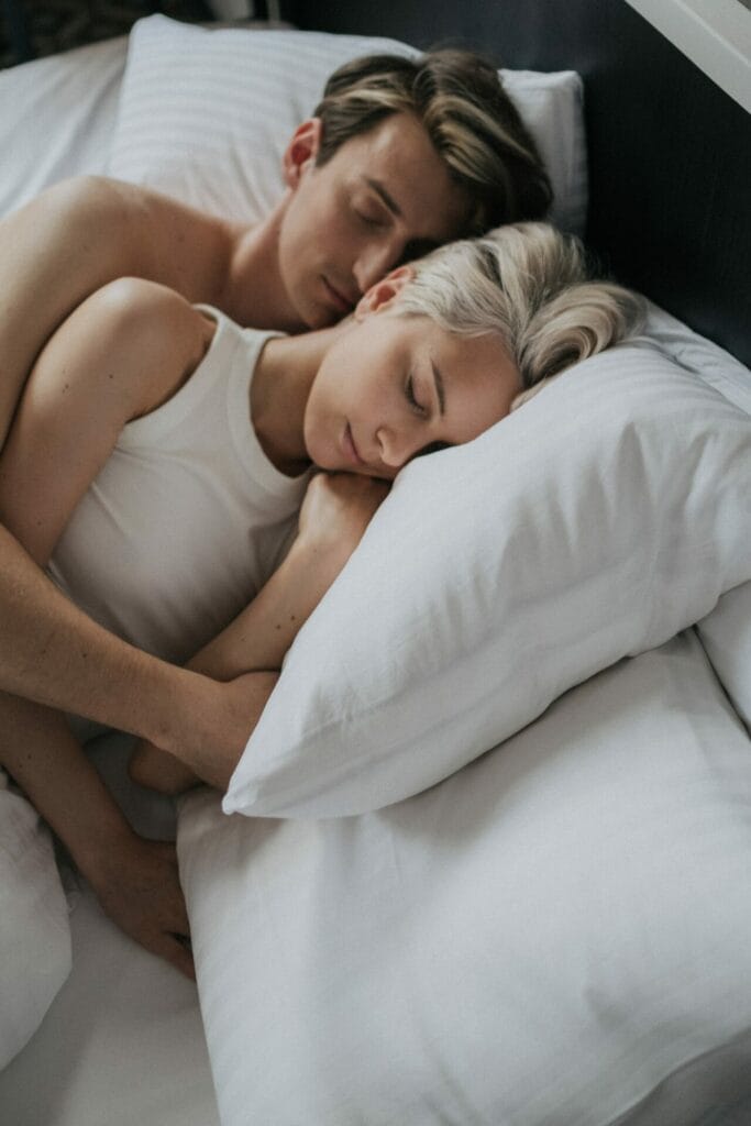 Ζευγάρι κοιμάται αγκαλιά στο κρεβάτι.