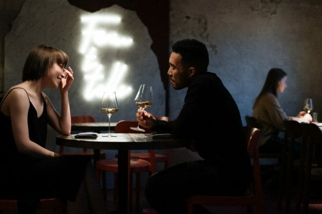 Γυναίκα και άνδρας σε ραντεβού συζητούν και πίνουν κρασί