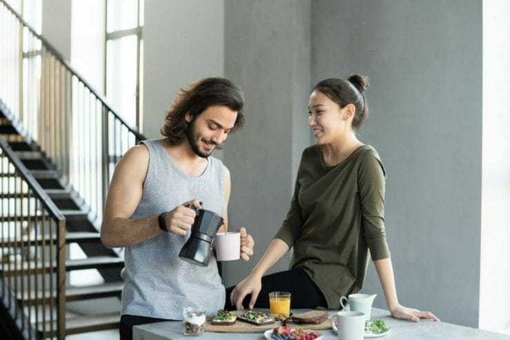 Ζευγάρι χαμογελάει ενώ ο άνδρας σερβίρει καφέ